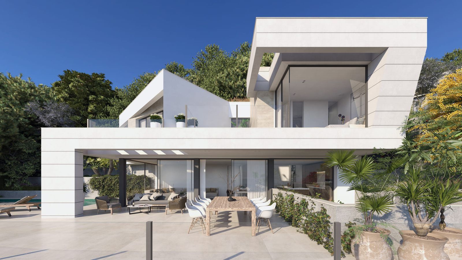 Moderne witte villa met grote glazen ramen, buiten eethoek en groen onder helderblauwe lucht.